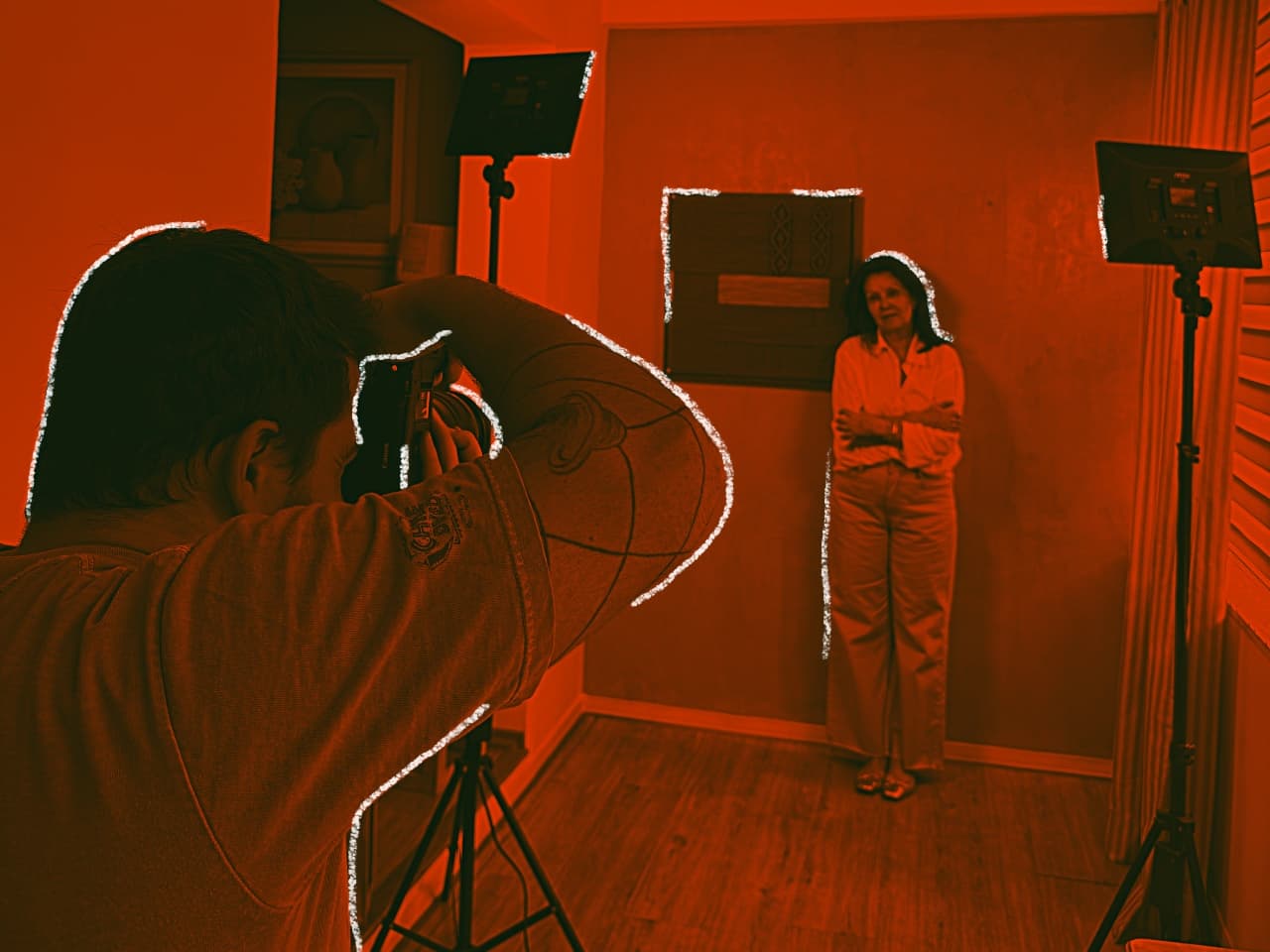 Orange-toned visual of a photographer capturing a subject during a content production shoot